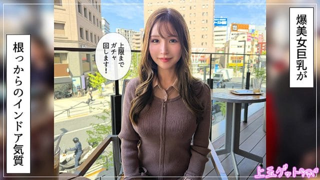 茶髪の女性がブラウンのリブニットを着て、屋外カフェのテラス席に座っている。背景には都市の街並みと青空が広がり、穏やかな微笑みを浮かべている。