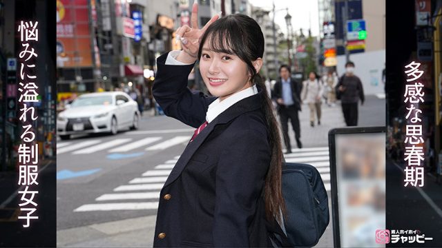 黒髪の女性が制服を着て街でピースサインをしながら微笑んでいる。